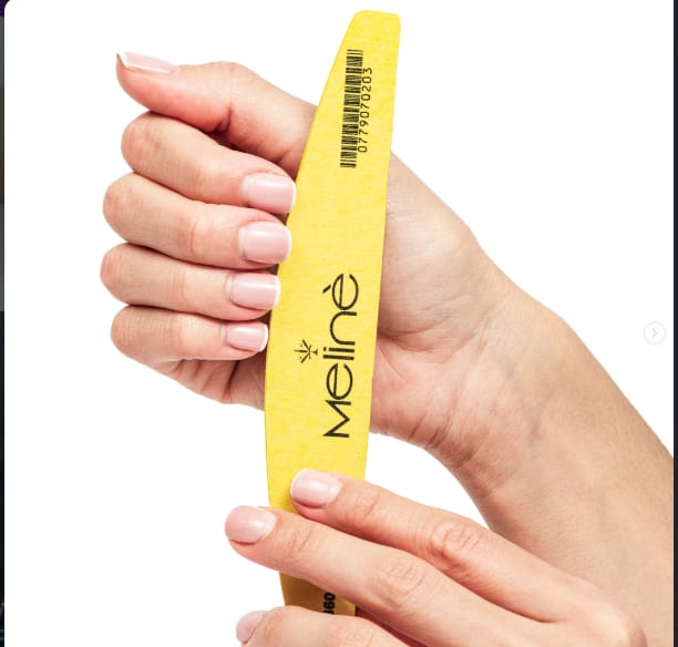 Manos sosteniendo una lima de uñas amarilla
